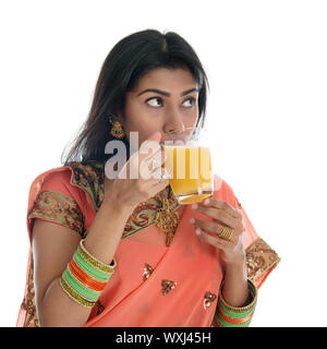 Traditionelle indische Frau in Sari trinken Orangensaft, isoliert auf weißem Hintergrund. Stockfoto