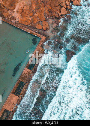 Ansicht von oben eine Frau schwimmen in Cronulla Beach Rock Pool, Sydney, New South Wales, Australien Stockfoto