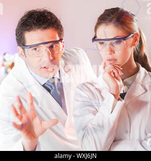 Porträt einer fokussiert Health Care Professionals in ihrem Arbeitsumfeld schreiben strukturelle chemische Formel auf ein Glas. Stockfoto