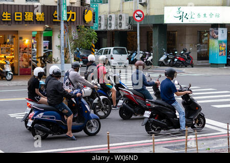 Kaohsiung, Taiwan: Roller Fahrer und Bus warten auf Kreuzung leuchtet am Tag grün Stockfoto