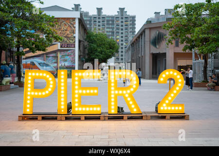 Kaohsiung, Taiwan: Der Name der Kaohsiung Bezirk Pier2 in riesigen gelben Neonbuchstaben an einem Platz am Tag geschrieben Stockfoto