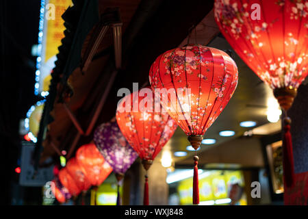 Kaohsiung, Taiwan - 15 April 2019: Schöne chinesische Hakka Laternen hängen neben einem Gebäude bei Nacht Stockfoto