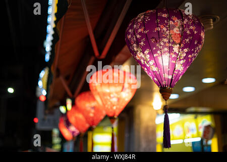 Kaohsiung, Taiwan - 15 April 2019: Schöne chinesische Hakka Laternen hängen neben einem Gebäude bei Nacht Stockfoto