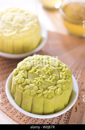 Snowy Haut mooncakes. Traditionelle Chinesische mid Autumn Festival essen. Die chinesische Wörter auf der Mooncakes bedeutet, dass grüner Tee mit roten Bohnen Paste und Lotus Stockfoto