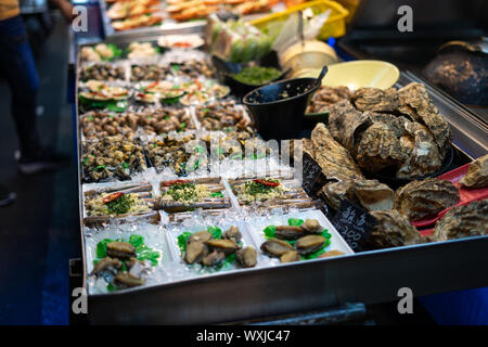 Kaohsiung, Taiwan: Street Food eine große Vielfalt an frischen Meeresfrüchten auf einem Bett aus Eis Stall bietet in der Nacht. 六合夜市 Stockfoto