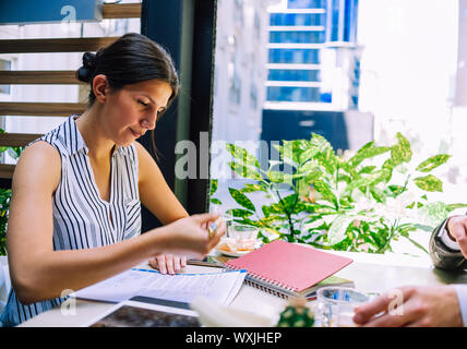 Schöne Geschäftsfrau mit Ihrem Smartphone auf business meeting in Caffee shop Stockfoto