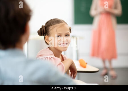 Mädchen mit zwei Haar Brötchen in der Pause in der Schule lachen Stockfoto