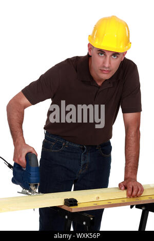 Handwerker, die Herstellung der Löcher in einem Brett mit einem Bohrer Stockfoto