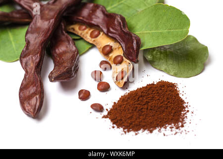 Johannisbrot. Gesunde organische süße Johannisbrot Schoten mit Samen und Blätter auf weißem Hintergrund Stockfoto