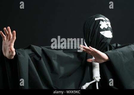 Schwarz mime mit Seil um den Hals auf schwarzem Hintergrund Stockfoto