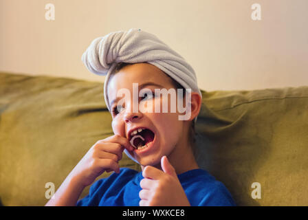 Mädchen sitzt auf einem Sofa ihre Zähne flossing nach Ihrer Dusche Stockfoto