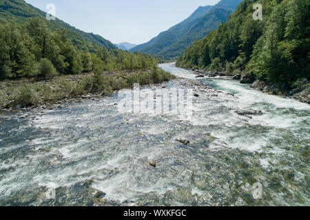 Mountain River zwischen Holz in einer alpinen Tal fließt. Luftaufnahme. Sesia Fluss in Verbania, Piemont, Italien. Stockfoto