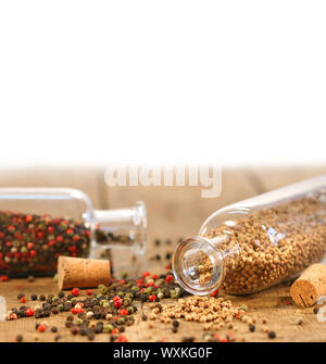 Flaschen von Gewürzen auf rustikalen Holztisch Stockfoto