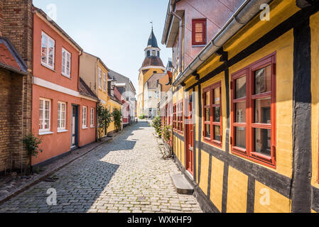 Eine Gasse mit Kopfsteinpflaster und Fachwerkhäusern, die bis zur Kirche in Faaborg, Dänemark, 12. Juli 2019 Stockfoto