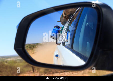 In den hinteren Look Rückspiegel, auf einer sandigen Weg in Namibia fahren Stockfoto