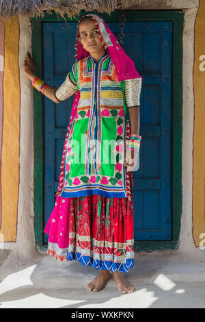 Mädchen in traditionellen Tuch vor einem Haus, Khavda Tourist Village, tolle Rann von Kutch Wüste, Gujarat, Indien. Stockfoto