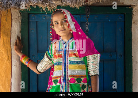 Mädchen in traditionellen Tuch vor einem Haus, Khavda Tourist Village, tolle Rann von Kutch Wüste, Gujarat, Indien. Stockfoto