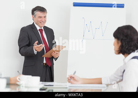 Geschäftsmann, seine Kollegin Notizen mit Lächeln zu erklären Stockfoto