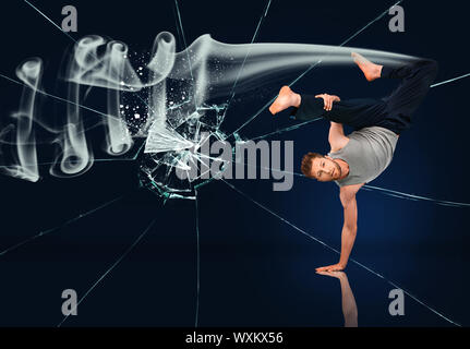 Martial-Arts-Experte Hand Stand mit Rauch hinter ihm vor Glasscherben Hintergrund zu tun Stockfoto