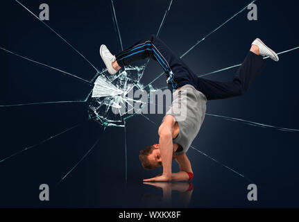 Break Dancer balancieren auf Unterarme auf gebrochene Glas Hintergrund Stockfoto