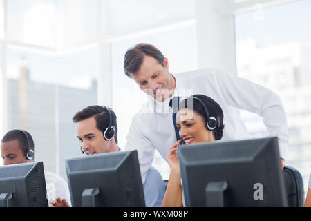 Manager Call Center Mitarbeiter arbeiten am Computer hören Stockfoto