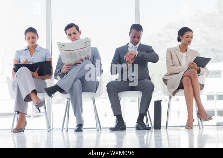 Wartezimmer mit Business-Leute saßen in Linie Stockfoto