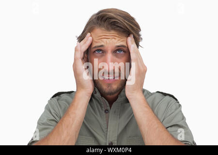 Mann verzog das Gesicht, mit Schmerz der Kopfschmerzen und blickte auf weißem Hintergrund Stockfoto