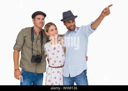 Mann zeigte auf etwas mit Freunden und einer hat Kamera auf weißem Hintergrund Stockfoto