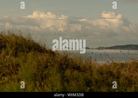 Niedrige wogenden Fluffy Clouds über eine Ebbe in Swansea, Wales, Großbritannien Stockfoto