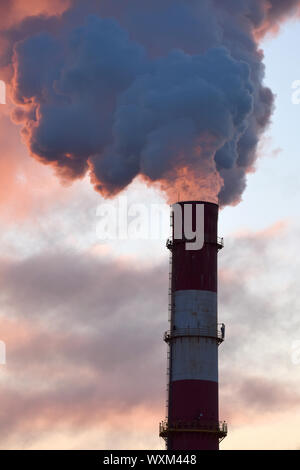 Factory Schornstein mit raucht bei Sonnenuntergang in Vilnius, Litauen Stockfoto