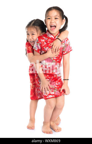 Schöne orientalische asiatische Mädchen in traditionellen Chinesisch Cheongsam spielen, isoliert in voller Länge auf weißem Hintergrund Stockfoto