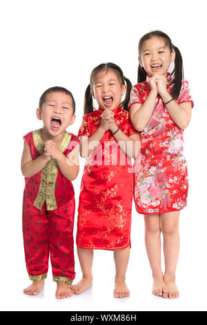 Gruppe von orientalischen Kinder, ich wünsche Ihnen ein frohes chinesisches neues Jahr, mit traditionellen Cheongsam in voller Länge ansehen isoliert auf weißem Hintergrund. Stockfoto