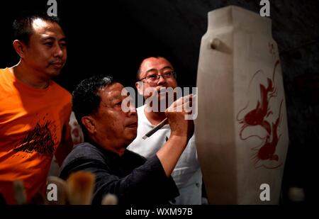 (190917) - SHIJIAZHUANG, Sept. 17, 2019 (Xinhua) - Liu Lizhong (C) führt seine Söhne auf die cizhou Brennofen Porzellan in einem Museum in Handan Stadt, im Norden der chinesischen Provinz Hebei, Sept. 12, 2019. Liu Lizhong, 75, ist ein Erbe der Cizhou Kiln firing Technik. Als vierte Generation in seiner Familie von Porzellan, Liu hat sich dem Erhalt und der Erforschung der traditionellen Brennofen brennen Fähigkeiten gewidmet, und hat erfolgreich den intakten 72 Verfahren der Cizhou Brennofen brennen geerbt. Mit mehr als 100 Auszubildende eingestellt, sagte er seinen Traum ist das traditionelle Handwerk auf jüngere ge weitergeben Stockfoto