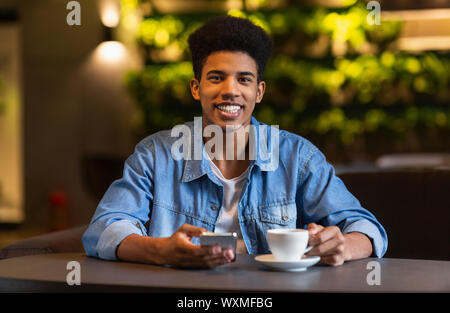 Freundliche schwarze Teen guy Kaffee trinken in der Cafeteria Stockfoto