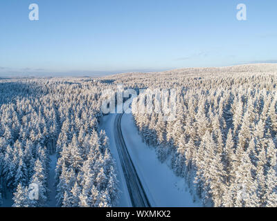 Eine Autobahn überqueren der nördlichen Taiga Wald im Winter in Lappland, Finnland Stockfoto