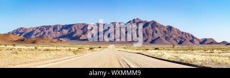 Schotterstraße in eine bergige Landschaft in der Nähe von Spreetshoogte Pass, Namibia führenden Stockfoto