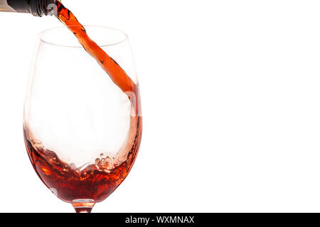 Rotwein in Glas vor weißem Hintergrund Stockfoto