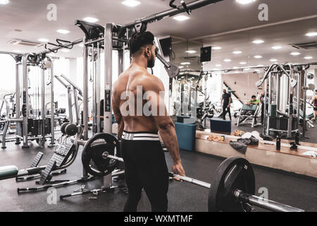 Muskulöse Mann tun, schweres Kreuzheben Übung. Junge Athlet, bereit für Gewichtheben Ausbildung Stockfoto