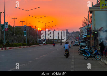 Pakse Laos - Feb 2016: Hauptstraße mit Verkehr in bunten Sonnenuntergang in Thakhek, Laos Stockfoto