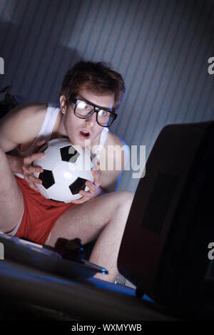 Junger Mann Fußball-Fanatiker immer wirklich in das Fußballspiel im Fernsehen Stockfoto