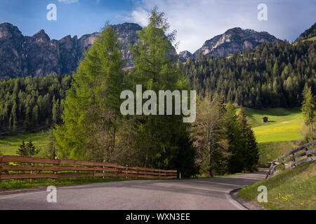 Sonniger Frühlingstag in Dolomiten, malerische Val di Funes. Felsigen Gipfeln und bewaldete Berge von grünen Almen umgeben. Südtirol, nördlich von Stockfoto