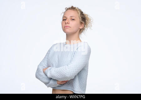 Junge selbstbewusste Frau mit Stolz und arrogant Emotionen im Gesicht. Curly blonde Mädchen selbst stolz und kümmert sich nicht um andere Menschen Stockfoto