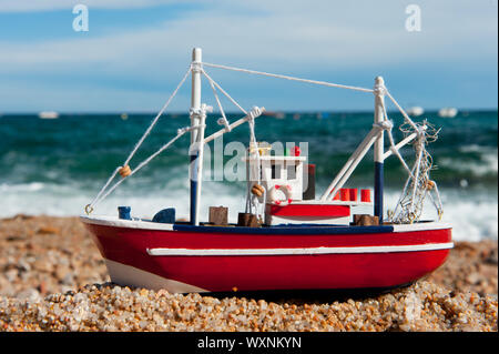 Holz- Fischerboot in Miniatur am Strand Stockfoto