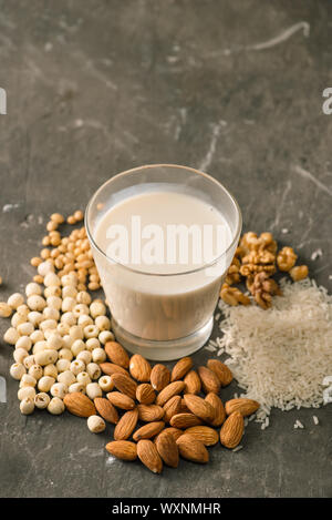 Gläser Milch mit Muttern: Macadamianüsse, Mandeln, Soja, Reis, Lotus. Ansicht von oben. Stockfoto