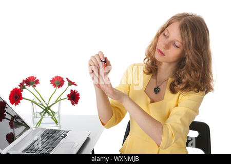 Junge Frau Isbringing Nagellack auf hinter ihrem Schreibtisch Stockfoto