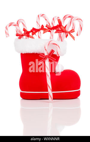 Santas Boot mit Zuckerstangen auf weißem Hintergrund Stockfoto