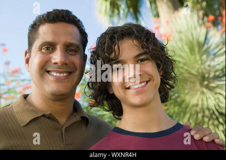 Vater mit Arm um Sohn Stockfoto