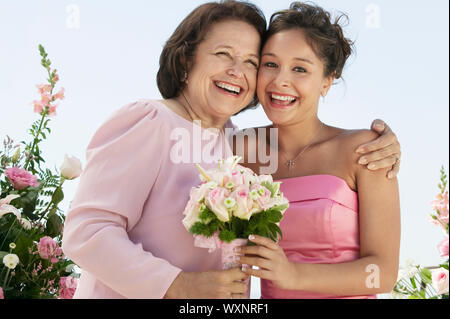 Glückliche Mutter und Braut mit Blumenstrauß Stockfoto