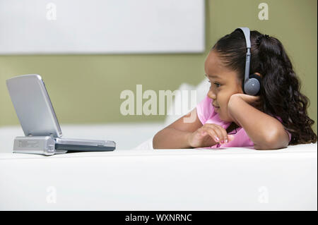 Kleines Mädchen beobachten, tragbare DVD-Player Stockfoto