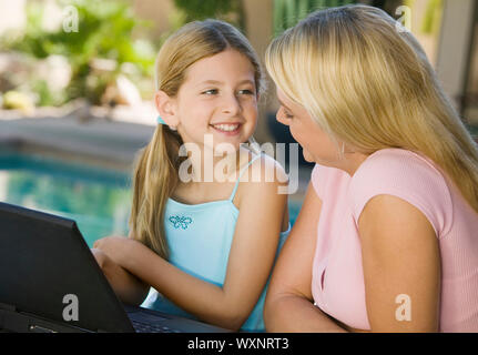 Mutter und Tochter mit Laptop auf Terrasse Stockfoto